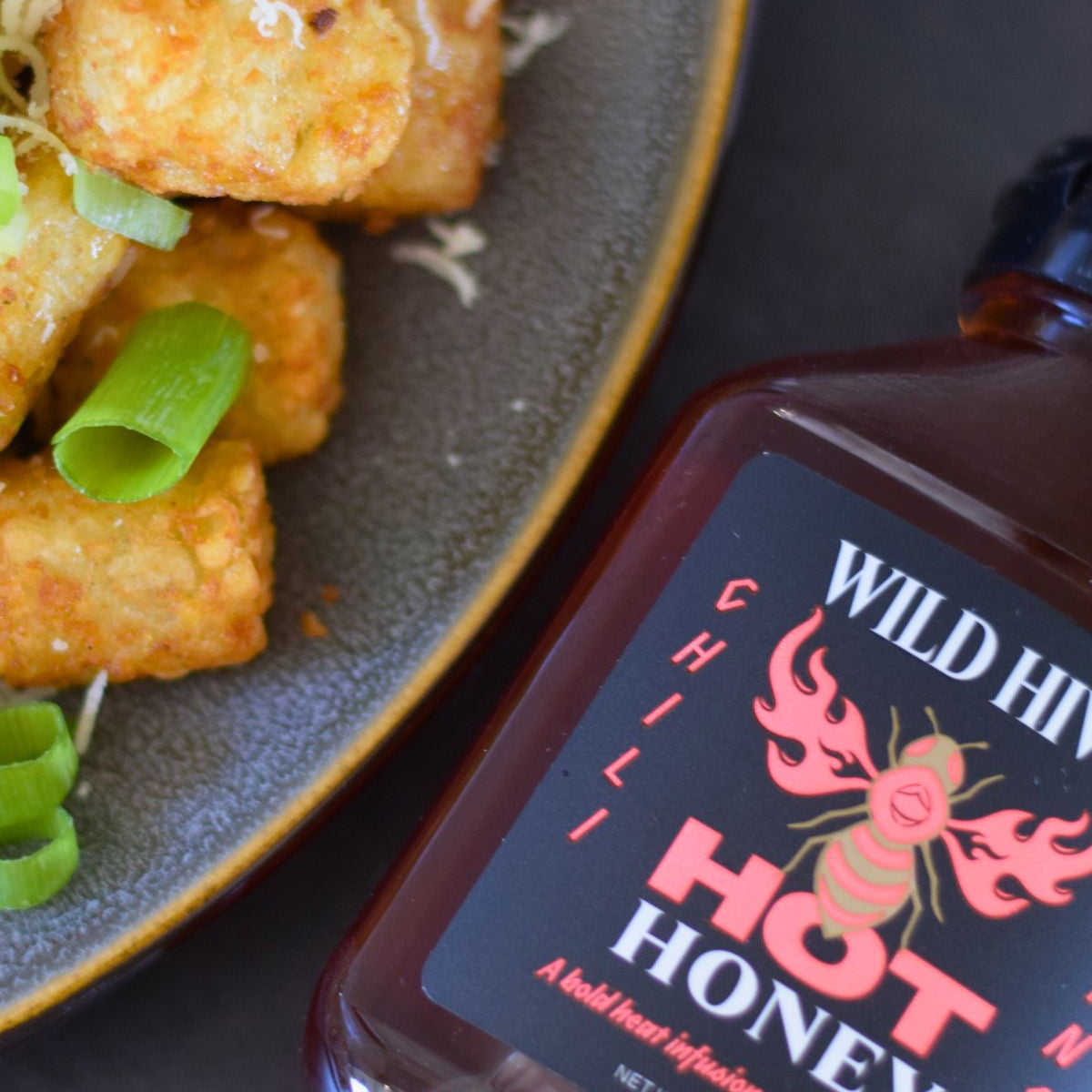 Image of Wild Hive Hot Honey Chili Sting with tots and green onions. 